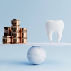 Extracted tooth balanced against stacks of coins
