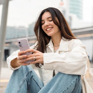 Lady smiles while reading something on phone