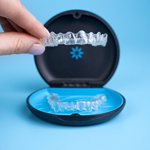 A woman placing her Invisalign aligner in a storage container