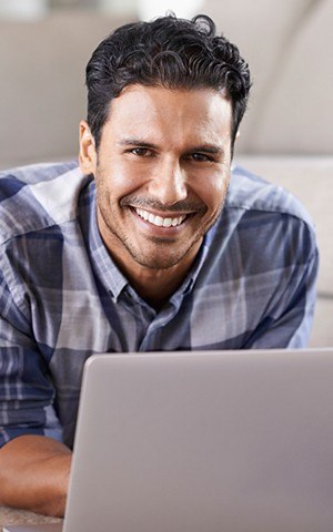 man smiling on laptop