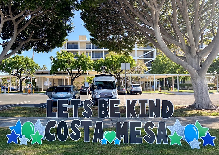 lets be kind costa mesa sign in front of building