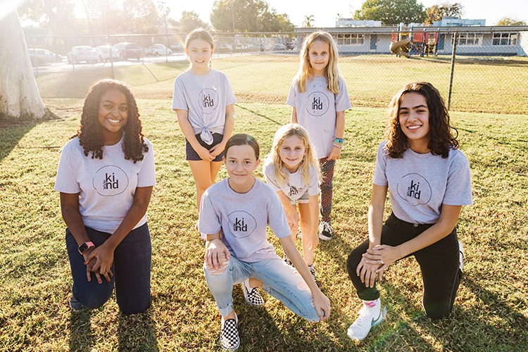 group of kids with lets be kind logo on shirts