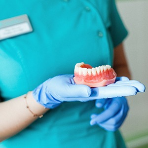 a closeup of a dental assistant holding dentures
