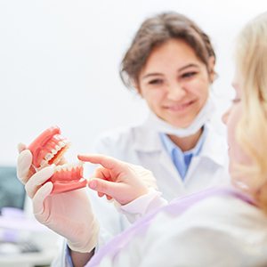 a patient with dentures chatting with their dentist