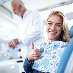 woman giving a thumbs up in the dental chair 