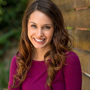 A woman smiling outside.