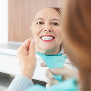 older woman smiling in mirror