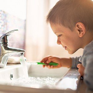 young boy brushing teeth