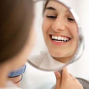 teen smiling into mirror