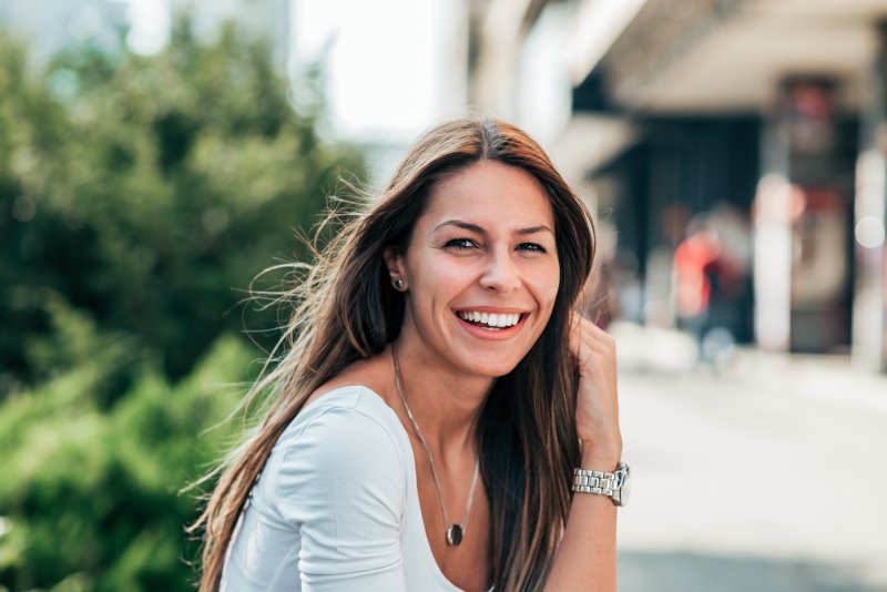 young woman smiling while wearing Invisalign