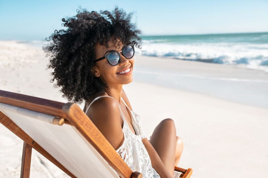 A woman smiling on a beach chair
