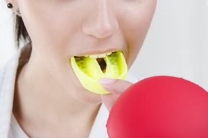 woman putting on mouthguard