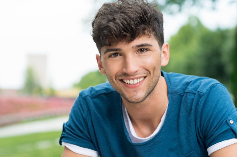 A teenager smiling outside.