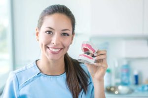 a person smiling and holding their dentures 