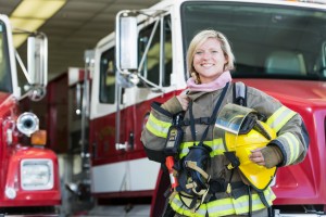 Female firefighter standing in front of fire truck