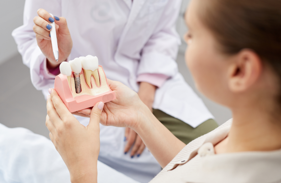 Dentist showing patient dental implant model